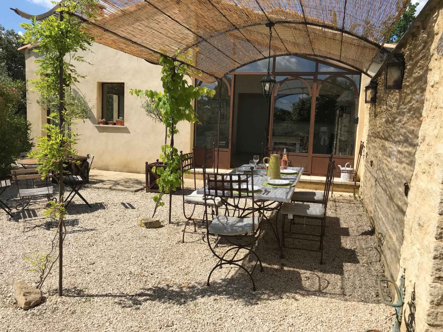 An outdoor dining area under a reed pergola at La Maison de Lune villa rental Provence