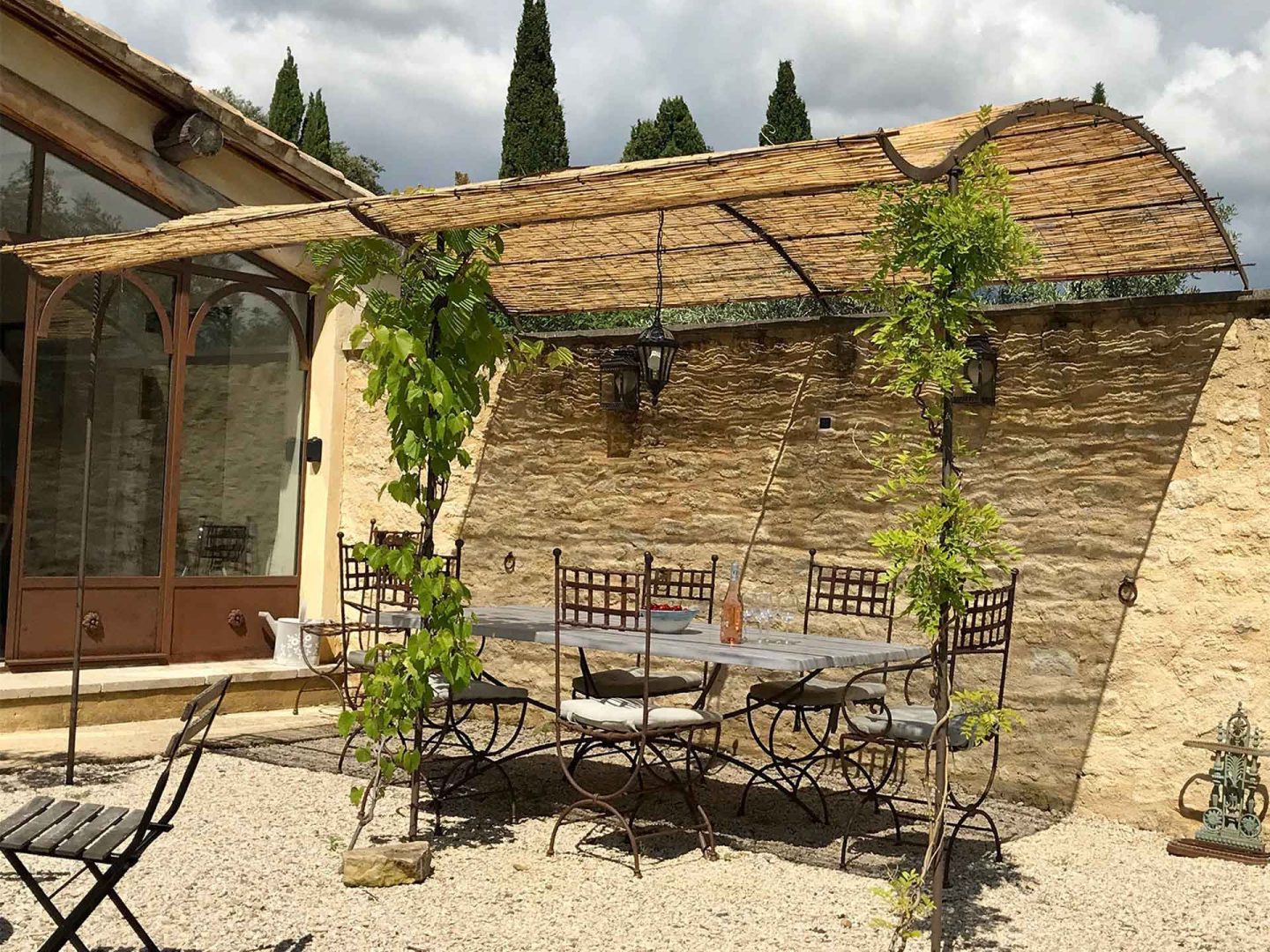 Outdoor dining area under a reed pergola at La Maison de Lune, one of the premier holiday homes Provence